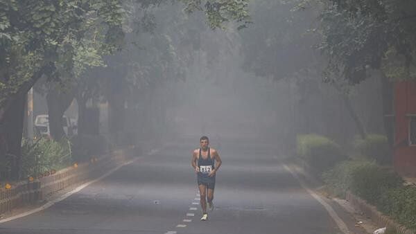 <div class="paragraphs"><p>A man jogs as he participates in a marathon while the sky is enveloped with smog after Delhi’s air quality was classified as "hazardous" amidst severe air pollution, in New Delhi</p></div>