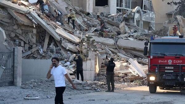 <div class="paragraphs"><p>Civil defence members walk on rubble at a damaged site in the aftermath of an Israeli strike in Tayouneh, amid the ongoing hostilities between Hezbollah and Israeli forces, Lebanon.</p></div>