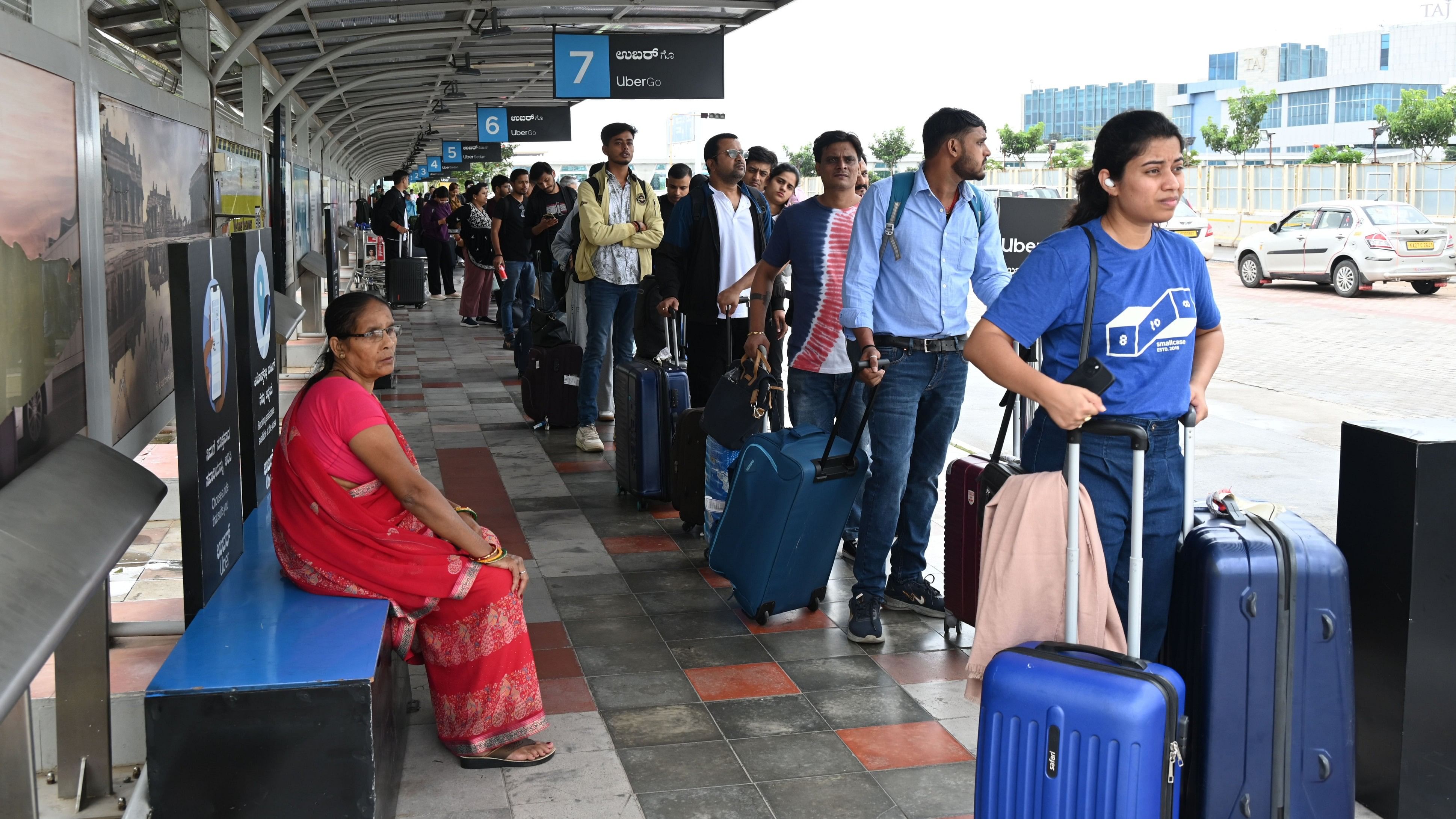 <div class="paragraphs"><p>Commuters waiting in a line for Uber cab at the Kempegowda International Airport in Bengaluru on Thursday. </p></div>