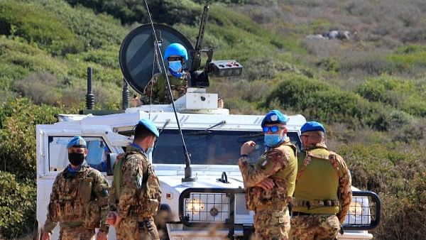 <div class="paragraphs"><p>UN peacekeepers (UNIFIL) stand near a UN vehicle. </p></div>