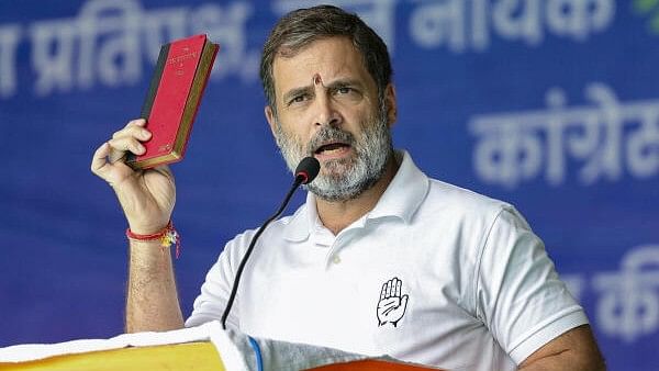 <div class="paragraphs"><p>Lok Sabha and Congress leader Rahul Gandhi holds a copy of the Constitution while addressing an election rally in Godda on Friday.</p></div>