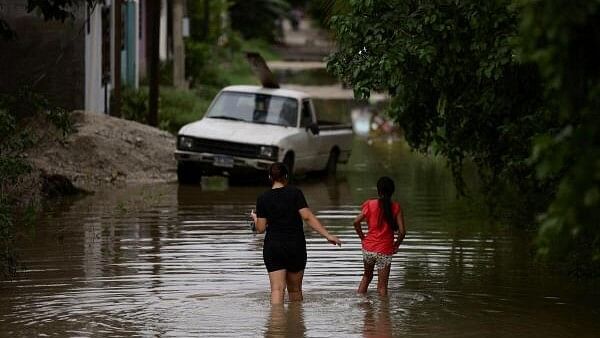 <div class="paragraphs"><p>People walk along a flooded street during the aftermath of tropical storm Sara, in San Pedro Sula, Honduras, November 17, 2024.</p></div>