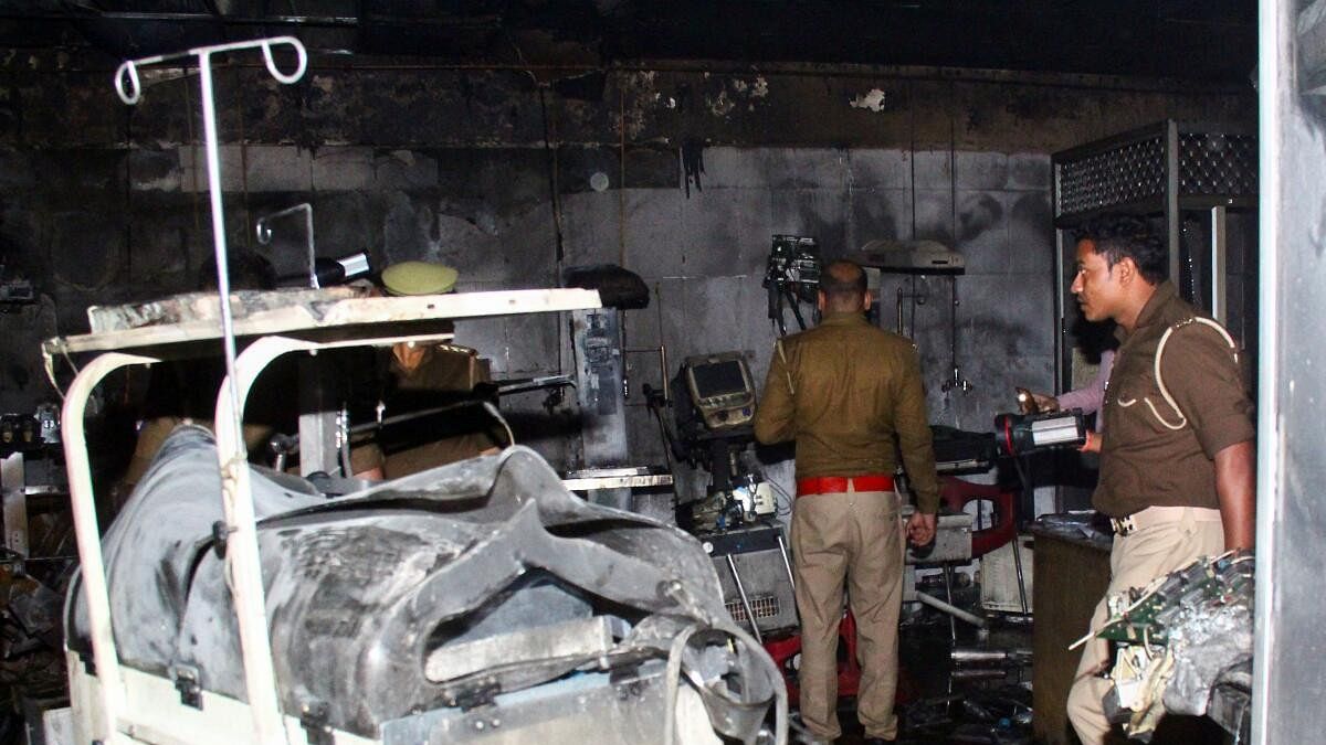 <div class="paragraphs"><p>Police officers examine the damaged neonatal intensive care unit after a fire broke out at the Maharani Laxmibai Medical College in Jhansi district.</p></div>