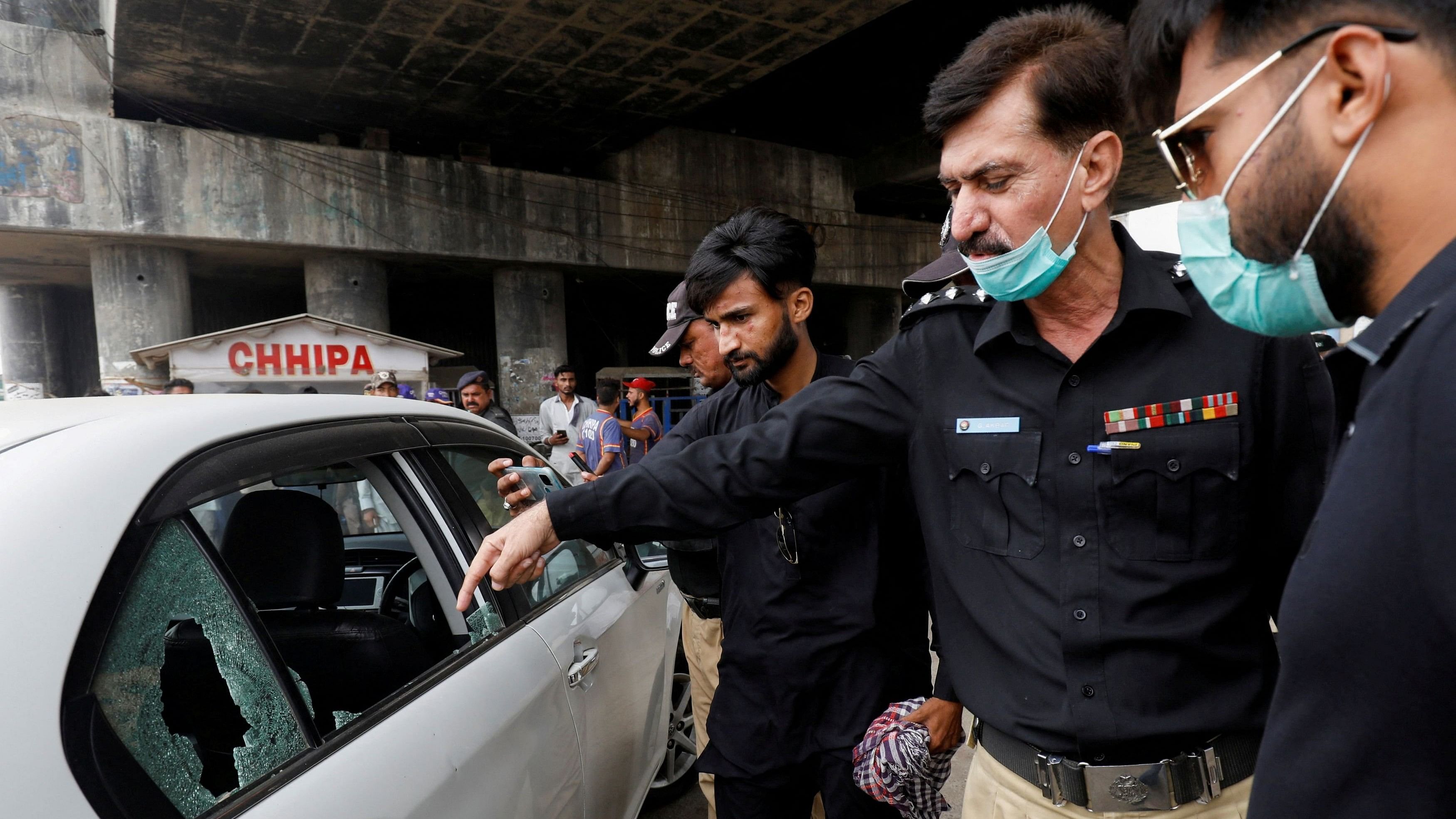 <div class="paragraphs"><p>A Pakistani police officer surveys the site after gunmen on a motorcycle opened fire on a vehicle belonging to a Chinese national, along a road in Karachi, Pakistan</p></div>