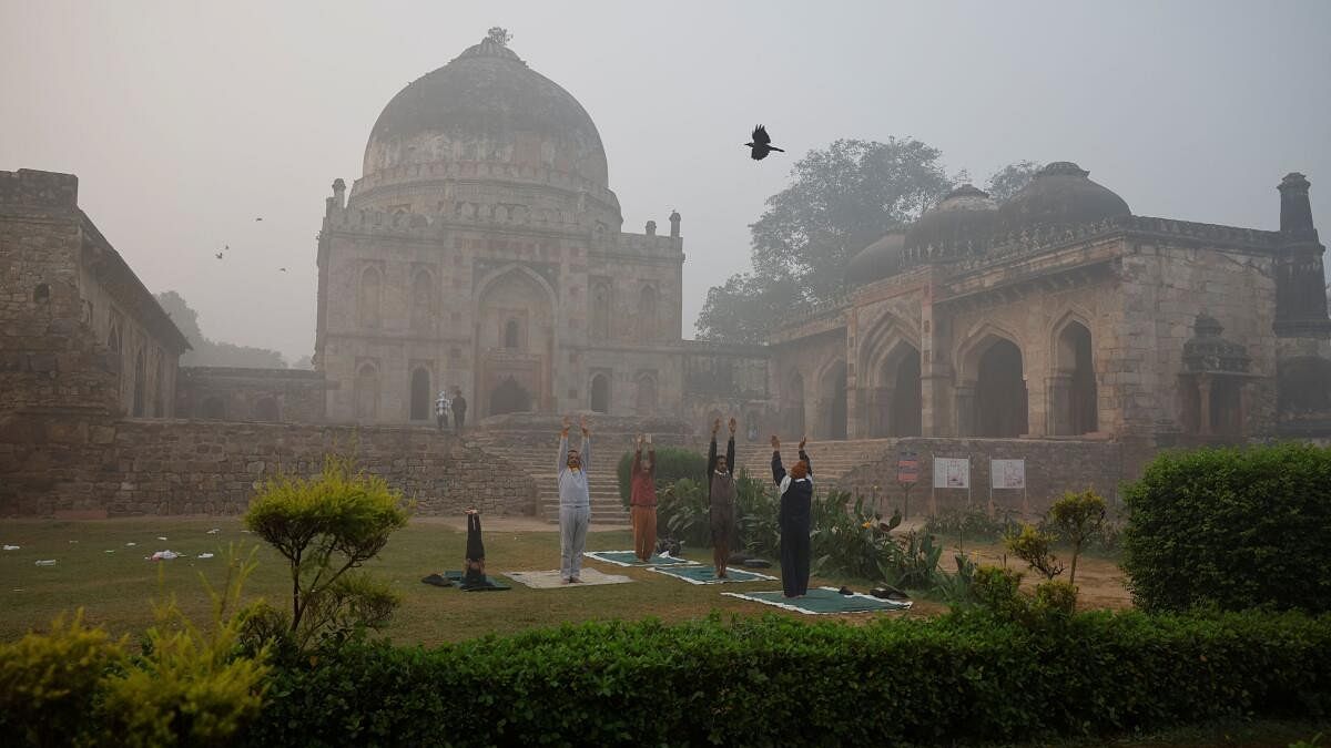 <div class="paragraphs"><p>People perform yoga at Delhi's Lodhi Garden as fog envelops the city</p></div>