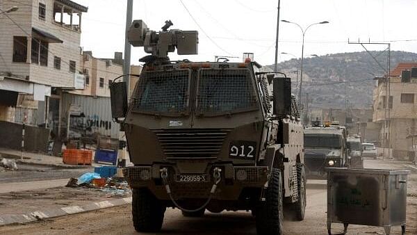 <div class="paragraphs"><p>Israeli military vehicles maneuver during an Israeli raid in Qabatiya, near Jenin in the Israeli-occupied West Bank.</p></div>