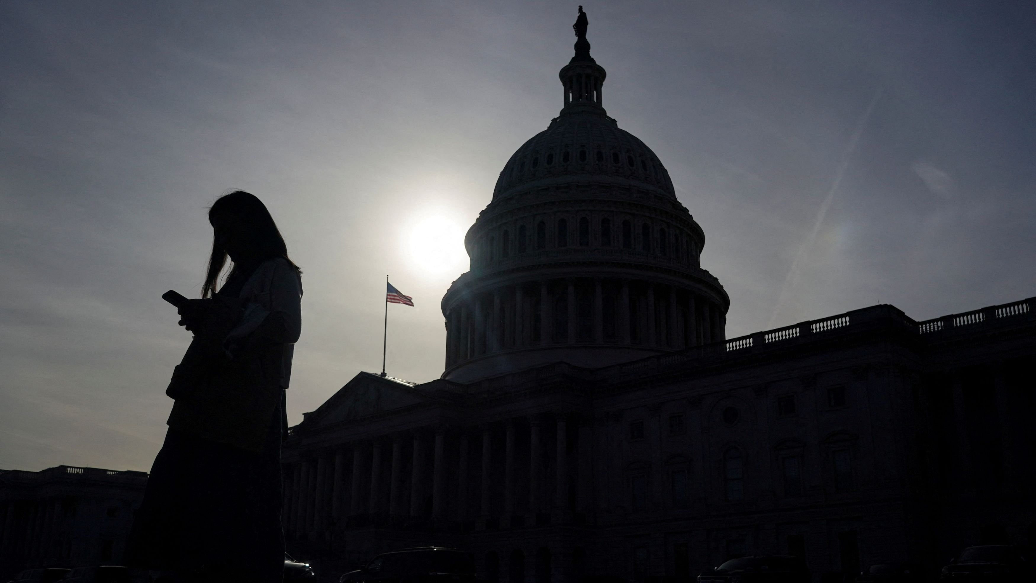 <div class="paragraphs"><p>A person uses a mobile phone with the US Capitol building in the background</p></div>