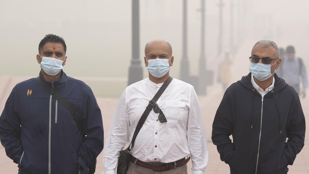 <div class="paragraphs"><p>Commuters walk to their office amid low visibility due to smog as air quility remains in severe category in New Delhi</p></div>