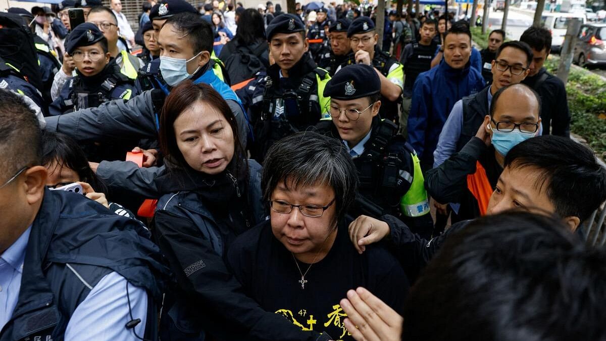 <div class="paragraphs"><p>A&nbsp;woman is taken away by police to search outside the West Kowloon Magistrates' Courts building, before the sentencing against the 45 convicted pro-democracy&nbsp;activists&nbsp;charged under the national security law, in Hong Kong, China November 19, 2024</p></div>