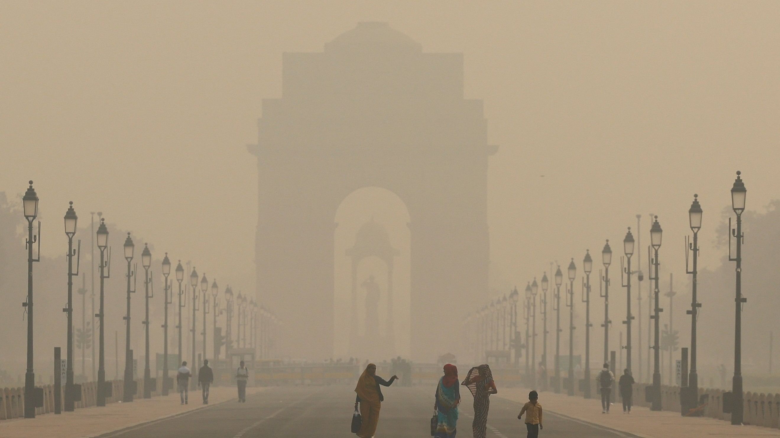 <div class="paragraphs"><p>Women walk on a road near India Gate as the sky is enveloped with smog after Delhi's air quality worsened due to air pollution, in New Delhi, India, November 19, 2024.</p></div>