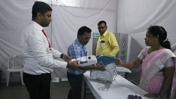 <div class="paragraphs"><p>Election officials make preparations at a polling station on the day of the Maharashtra state elections, in Mumbai.</p></div>