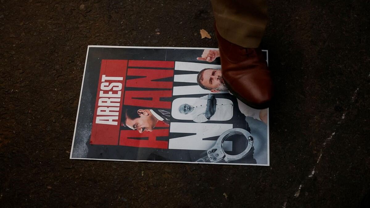 <div class="paragraphs"><p>A police officer stands on a placard during a protest by supporters of  Congress party against Indian billionaire Gautam Adani, after he was indicted in New York over his role in an alleged multibillion-dollar bribery and fraud scheme, in New Delhi, India, November 21, 2024.</p></div>