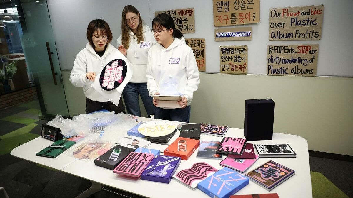 <div class="paragraphs"><p>Kpop4planet activists Park Jin-hui, Kim Na-yeon, and Roza de Jong work on signs made of K-pop idol fans' items and CD that will be used in a march ahead of the fifth session of the Intergovernmental Negotiating Committee (INC) on Plastic Pollution, in Seoul, South Korea.</p></div>