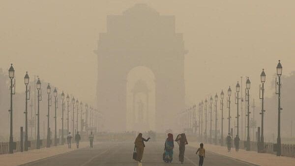 <div class="paragraphs"><p>Women walk on a road near India Gate as the sky is enveloped with smog after Delhi's air quality worsened due to air pollution, in New Delhi.</p></div>