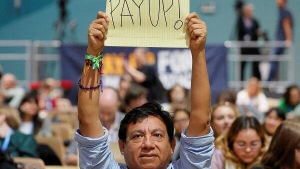 <div class="paragraphs"><p>An activist holds a placard during the 'People's Plenary' at the COP29 United Nations climate change conference, in Baku, Azerbaijan.</p></div>