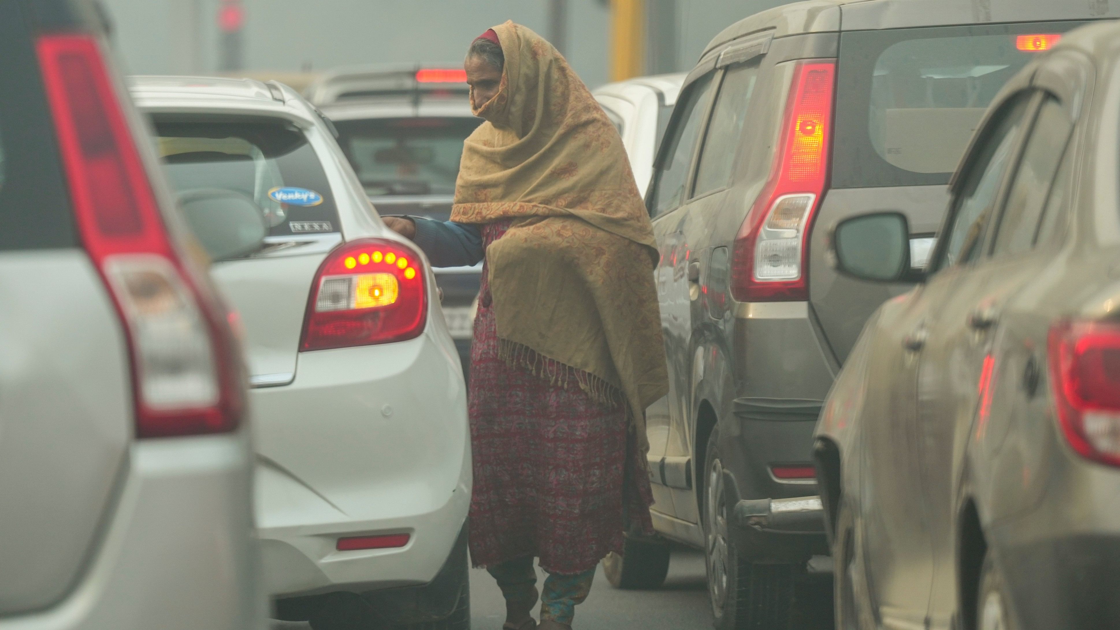 <div class="paragraphs"><p>An elderly woman seeks alms from travellers at a traffic signal.</p></div>