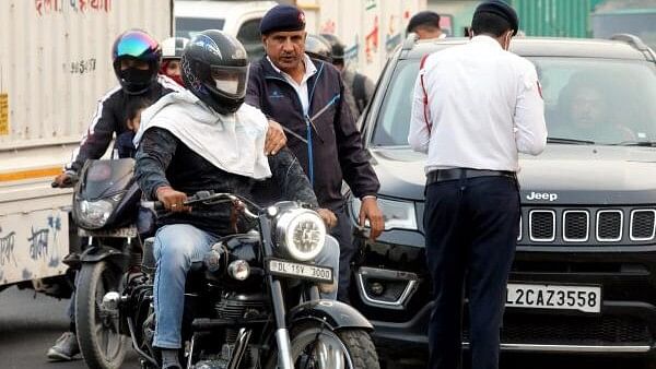 <div class="paragraphs"><p>A traffic police personnel stops a motorcyclist to check the Pollution Under Control (PUC) certificate of his bike, in New Delhi, Wednesday.&nbsp;</p></div>