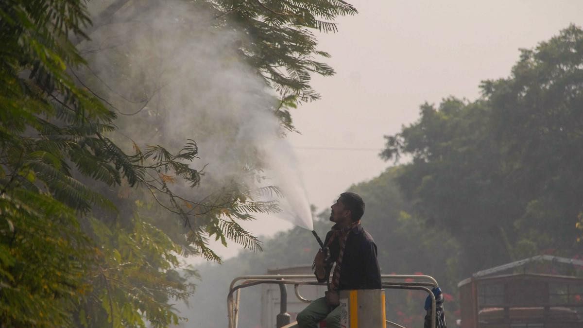 <div class="paragraphs"><p>A worker sprays water on trees to curb dust pollution, in Noida. </p></div>