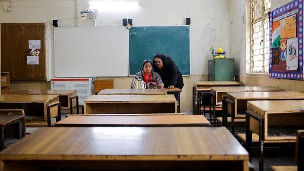 <div class="paragraphs"><p>School teachers conduct online classes using a mobile phone in an empty classroom after schools were ordered shut by the Delhi government as Delhi's air quality worsened due to air pollution, on a smoggy morning in New Delhi.&nbsp;</p></div>