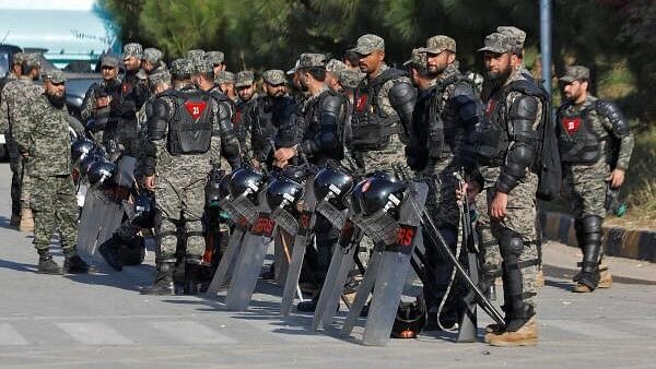 <div class="paragraphs"><p>Pakistani Rangers in riot gear stand guard alongside a road to prevent an anti-government rally by supporters of the former Pakistani Prime Minister Imran Khan's party Pakistan Tehreek-e-Insaf (PTI) in Islamabad, Pakistan.&nbsp;</p></div>