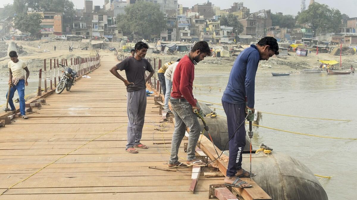 <div class="paragraphs"><p>Workers construct a temporary pontoon bridge over the Ganga river as part of preparations for the Maha Kumbh Mela 2025, in Prayagraj.</p></div>