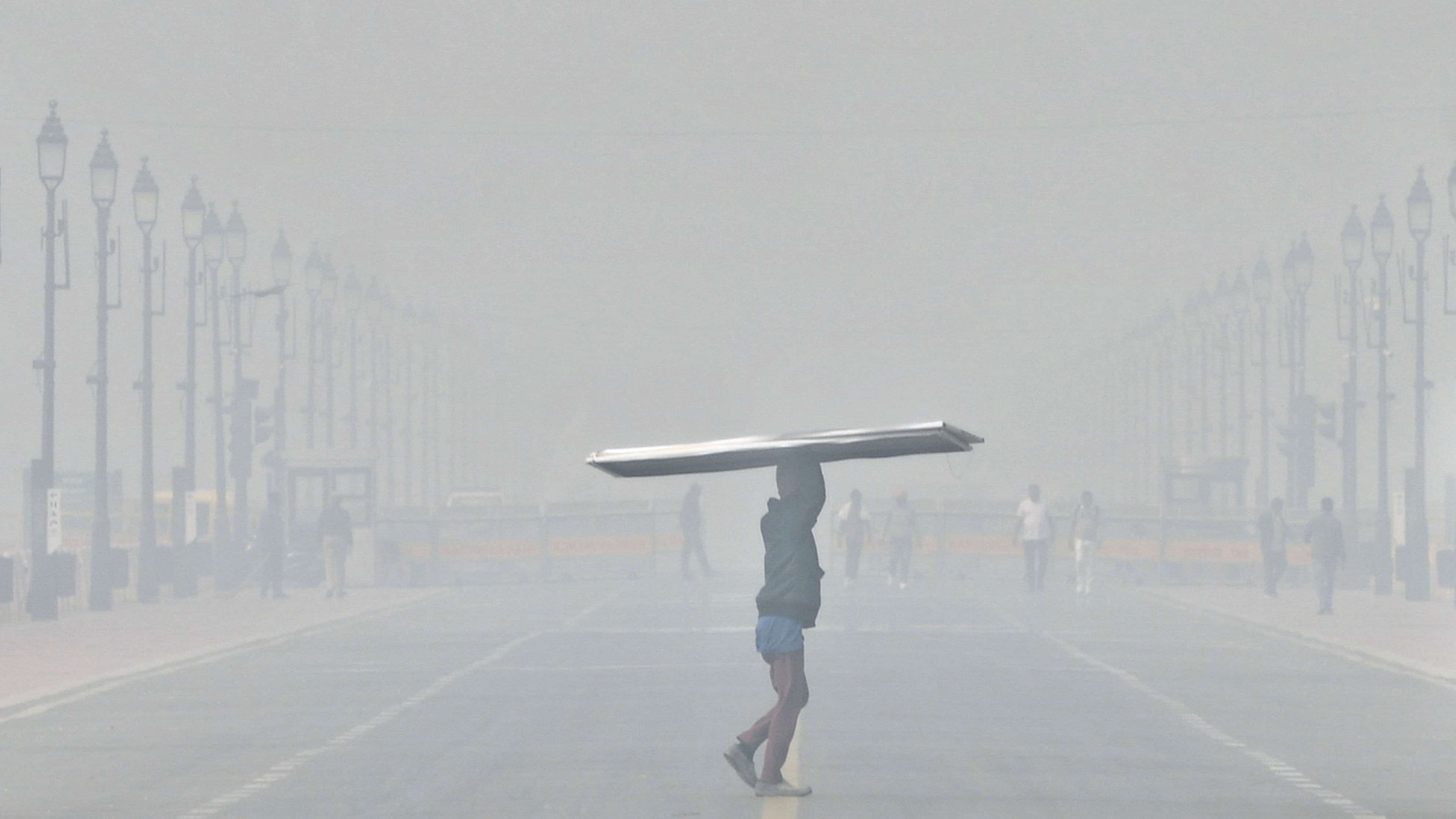 <div class="paragraphs"><p>A worker at Kartavya Path amid low visibility due to smog, in New Delhi</p></div>