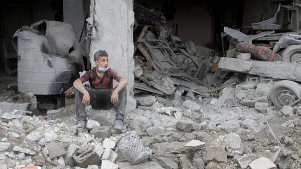 <div class="paragraphs"><p>A Palestinian boy sits amidst rubble at the site of an Israeli strike on a house, amid the ongoing conflict between Israel and Hamas, in Gaza City.&nbsp;</p></div>