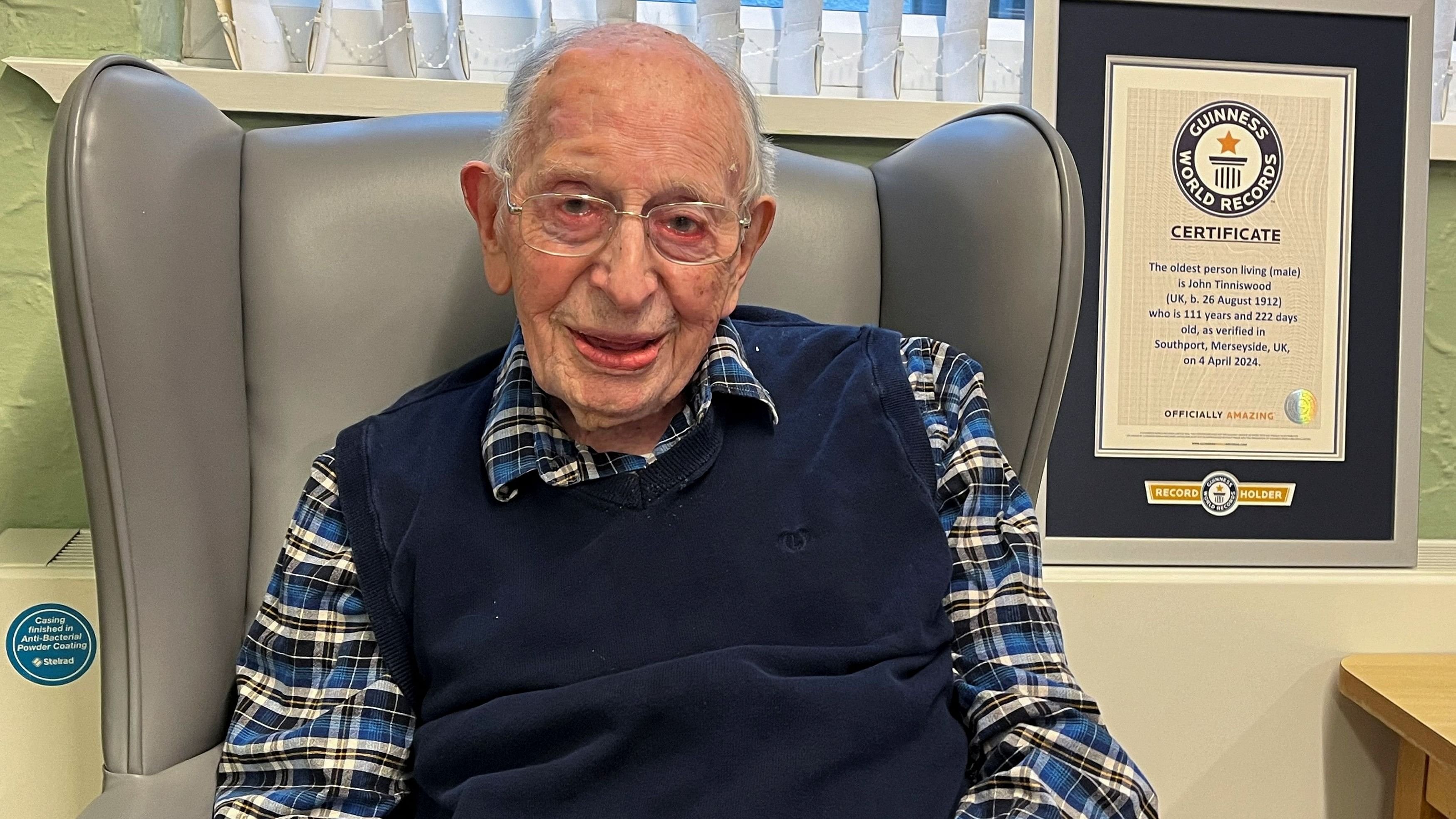 <div class="paragraphs"><p>John Tinniswood, then aged 111, poses with his certificate from the Guinness World Records, who announced that he is the world's oldest living man, in Southport, Britain.&nbsp;</p></div>