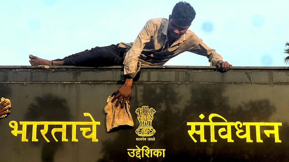 <div class="paragraphs"><p>A worker cleans a board on the eve of the 'Samvidhan Diwas', in Nagpur.</p></div>