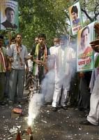 Congress Party workers burn fire-crackers as they celebrate party's winning trends outside AICC President Sonia Gandhi's residence in New Delhi on Sat