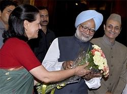 Congress President Sonia Gandhi presents a bouquet to Prime Minster Manmohan Singh as party leader Karan Singh looks on. PTI