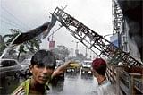A boy shouts as a bill board teeters during a cyclonic storm in Kolkata on Monday.  AFP