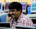 A stockbroker talks on the phone as he works at his terminal at a brokerage firm in Mumbai on Wednesday. AFP