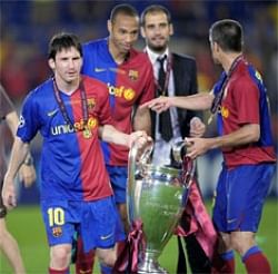 Barcelona's Lionel Messi (L), Thierry Henry hold the trophy while Coach Pep Guardiola looks on after the UEFA Champions League final  in Rome, AP