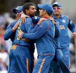 FIRST STRIKE:  Praveen Kumar is congratulated by his Indian team-mates after dismissing Pakistans Shahzaib Hasan in London on Wednesday.  AP