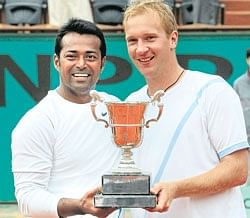 Leander Paes and Czech Republics Lukas Dlouhy celebrate with their trophy after defeating South Africas Wesley Moodie and Belgiums Dick Norman. AFP