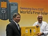 Samsung SW Asia HQ President and CEO J.S. Shin (L), and Minister for Renewable Energy Farooq Abdullah  with the first solar powered mobile phone. AP