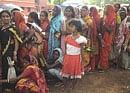 Villagers wait for rice at a government distribution centre at Lalgarh on Monday. AP