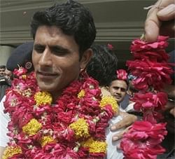 Pakistani cricketer Abdul Razzaq greeted with flower garlands by fans upon his arrival at Allama Iqbal airport in Lahore, Pakistan, early Wednesday.AP