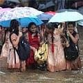 School girls move through a waterlogged street during rain in Mumbai on Friday. PTI