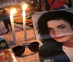 Photographs of late US singer Michael Jackson sit next to candles during a vigil in memory of him in Lima on Sunday. AP