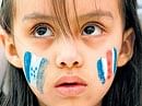 A child with her face painted with the flags of Honduras