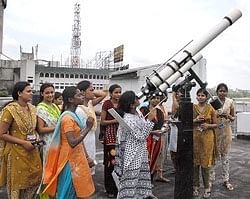Girls attend a training to observe the solar eclipse through a special telescope, a day before the event, in Patna on Tuesday. PTI