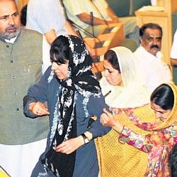 J&K Assembly security personnel remove PDP president Mehbooba Mufti (centre) from the hall after she wrenched a mike out of the Speakers podium. AFP