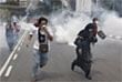 Protesters run as Police fire tear gas during an Anti Internal Security Act (ISA) demonstration in downtown Kuala Lumpur on Saturday. AP