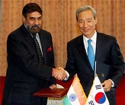 South Korean Trade Minister Kim Jong-hoon (R), shakes hands with India's Commerce minister Anand Sharma during a signing ceremony at Seoul, Friday. AP