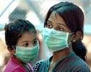 A woman and her kid wait to undergo H1N1 virus test at a special Screening Centre at Ram Manohar Lohia hospital in New Delhi on Saturday. PTI