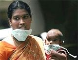 An attendant and her kid wear protective respiratory masks as a part of precautionary measures in Chennai on Monday. PTI
