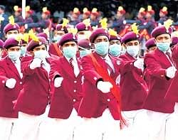Schoolchildren wear masks to guard against A(H1N1) influenza as they march during the Independence Day parade in Bangalore on Saturday. DH photo