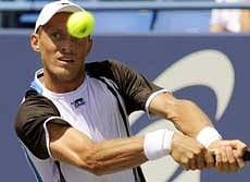 Russia's Nikolay Davydenko hits a return to Robert Kendrick during a second round singles match at the Pilot Pen tennis tournament in New Haven. AP